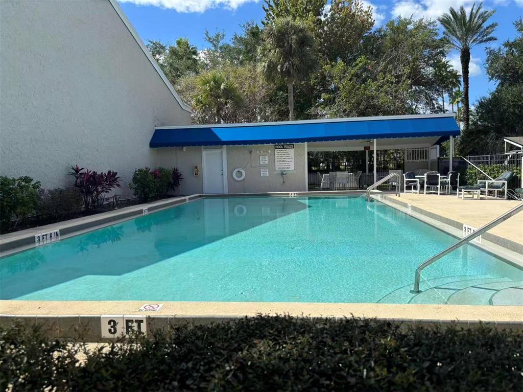 5395 Vineland Road, Unit S Orlando, FL 32811 - Photo 6 of 30 a view of a backyard with lawn chairs potted plants and large tree