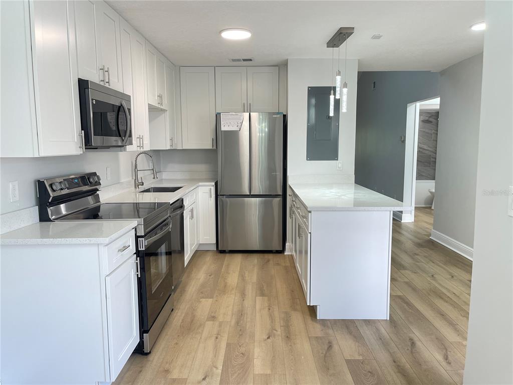 5395 Vineland Road, Unit S Orlando, FL 32811 - Photo 7 of 30 a kitchen with wooden cabinets and stainless steel appliances