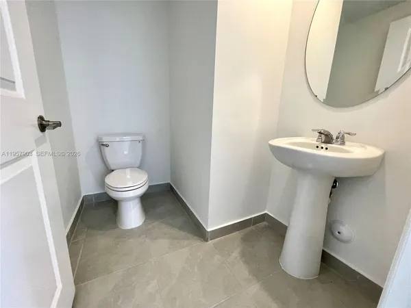 a bathroom with a sink toilet and a mirror