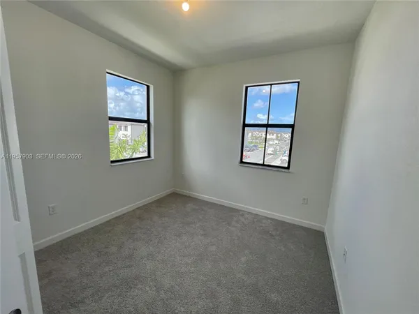 an empty room with windows and closet