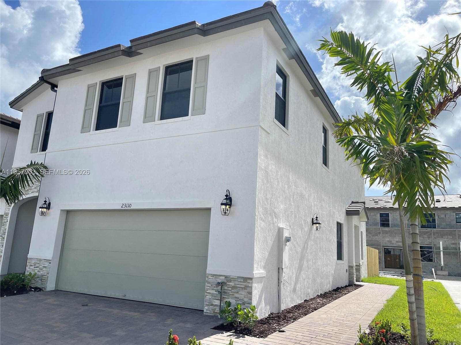23110 Southwest 129th Place, Unit 23110 Miami, FL 33177 - Photo 2 of 29 a front view of a house with garden