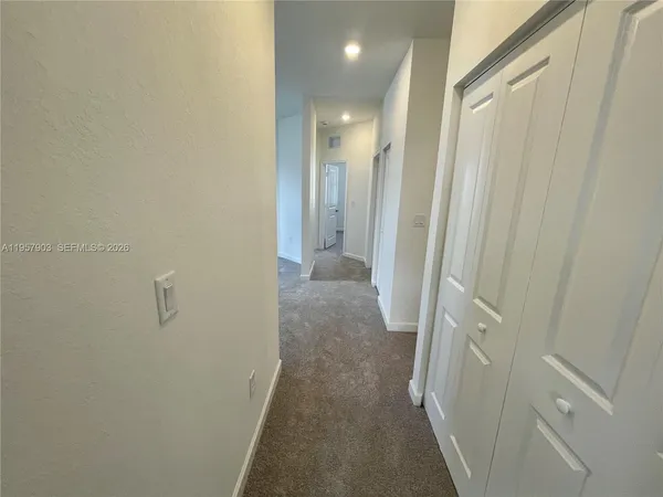 a view of a hallway with a refrigerator