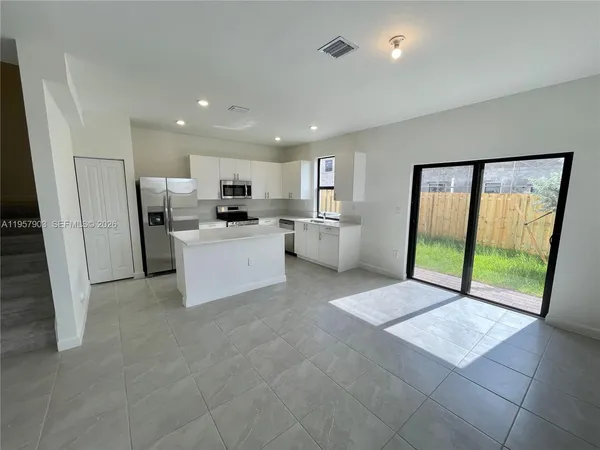 a open kitchen with a refrigerator a sink and a large window