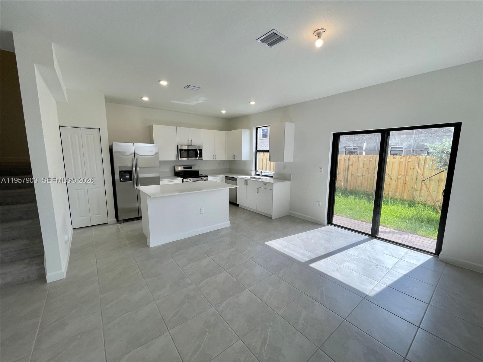 23110 Southwest 129th Place, Unit 23110 Miami, FL 33177 - Photo 7 of 29 a open kitchen with a refrigerator a sink and a large window