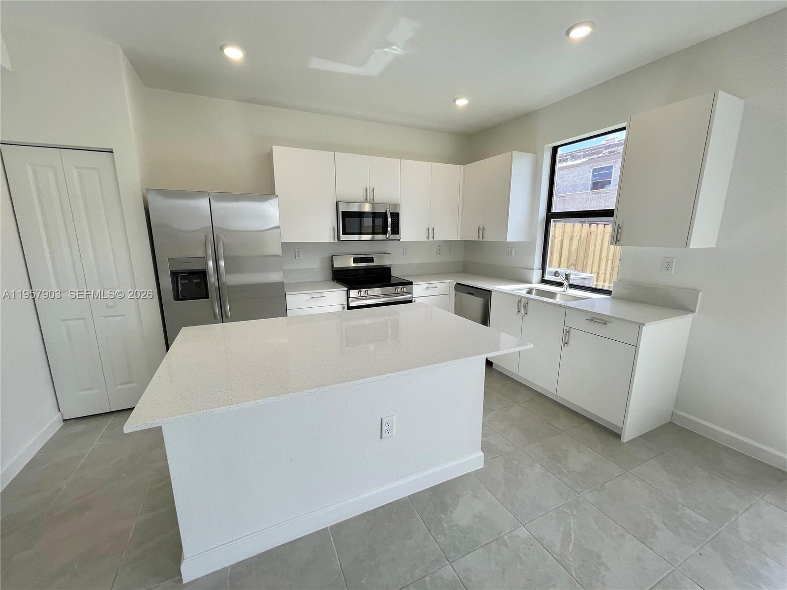 23110 Southwest 129th Place, Unit 23110 Miami, FL 33177 - Photo 8 of 29 a large white kitchen with cabinets