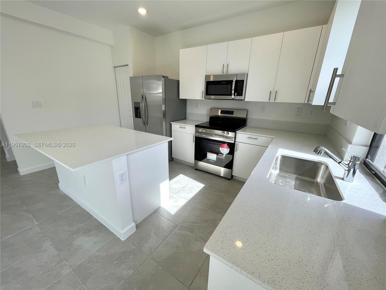 23110 Southwest 129th Place, Unit 23110 Miami, FL 33177 - Photo 9 of 29 a kitchen with a sink a stove and refrigerator