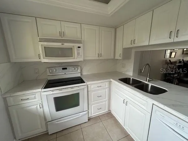 a kitchen with white cabinets and white appliances