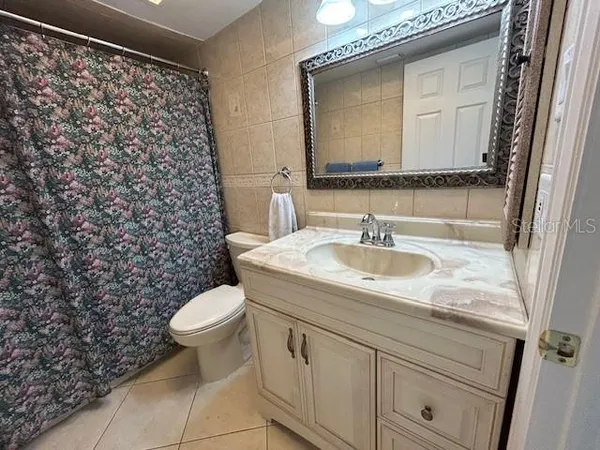 a bathroom with a granite countertop sink toilet and mirror