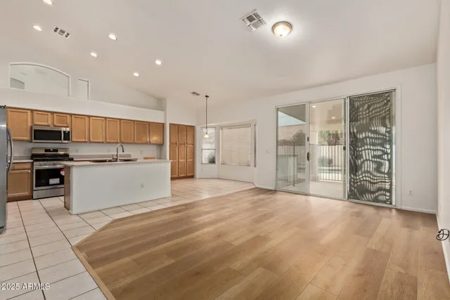 a view of kitchen with stainless steel appliances kitchen island wooden cabinets and granite counter tops