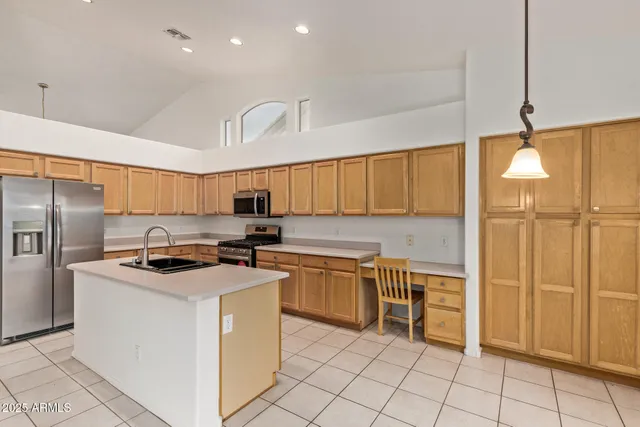 a kitchen with stainless steel appliances granite countertop a stove a sink and a refrigerator