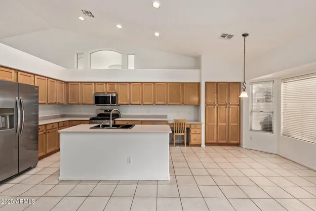 a kitchen with kitchen island a counter top space a sink cabinets and stainless steel appliances