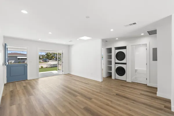 a view of a big room with wooden floor and windows