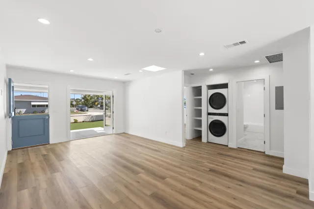 a view of a big room with wooden floor and windows