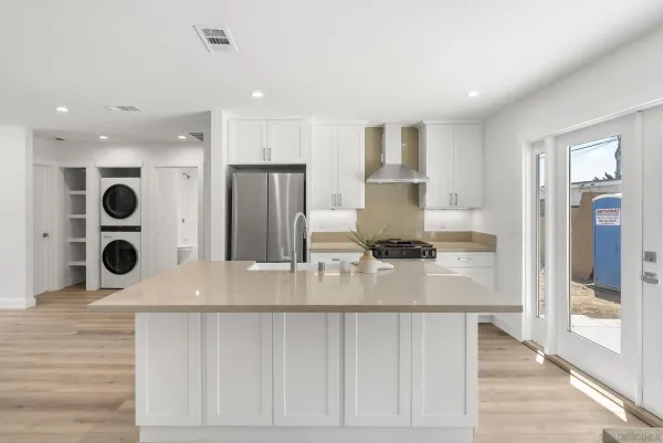 a kitchen with stainless steel appliances kitchen island granite countertop a refrigerator and a stove top oven