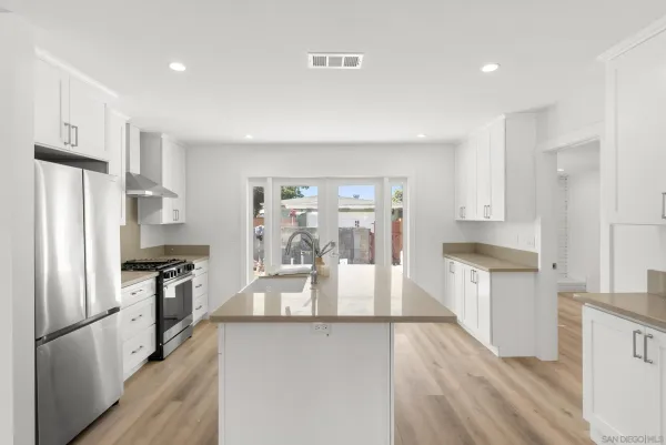 a kitchen with stainless steel appliances granite countertop a refrigerator sink and stove