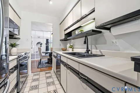 a kitchen with stainless steel appliances a sink stove and cabinets