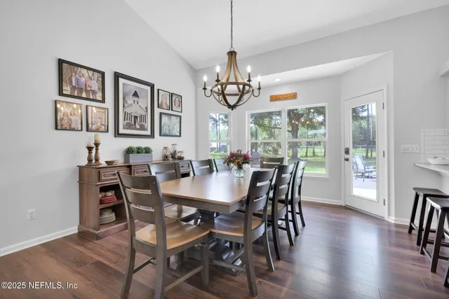 a kitchen with stainless steel appliances granite countertop a table chairs refrigerator and sink