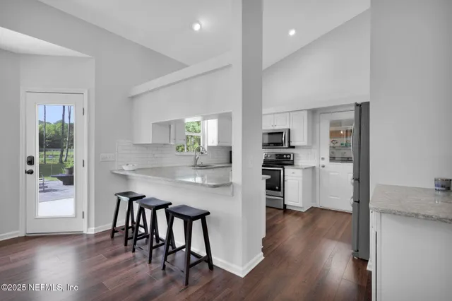a kitchen with stainless steel appliances white cabinets and a refrigerator
