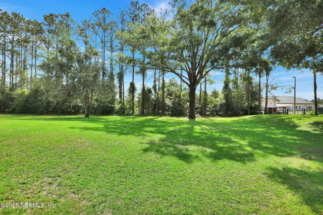an aerial view of a house with swimming pool and garden