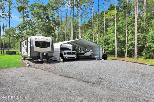 an aerial view of a house with a yard and lake view