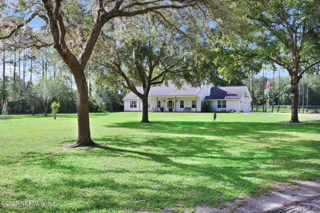 a view of a house with a yard deck and a tree