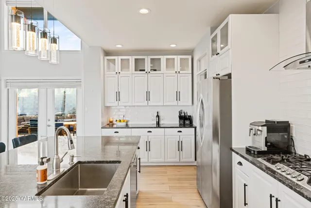 a kitchen with granite countertop a refrigerator and a sink