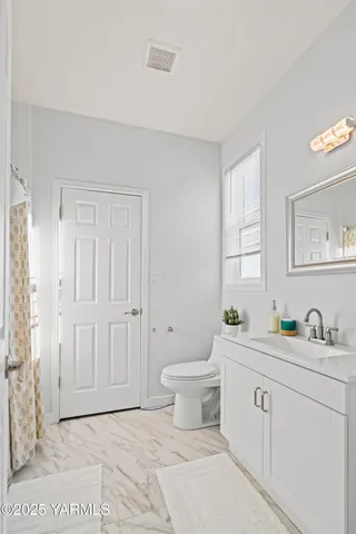 a bathroom with a toilet sink and mirror