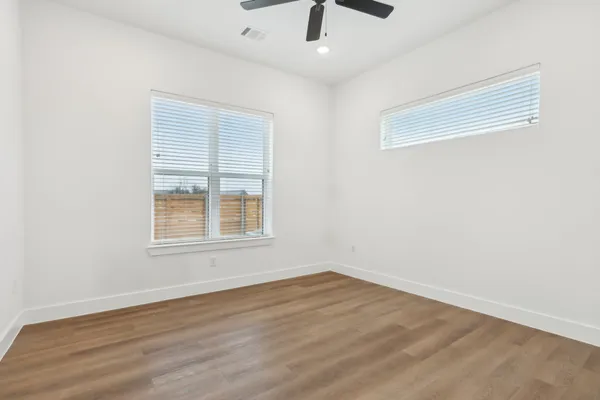 an empty room with a window and a ceiling fan