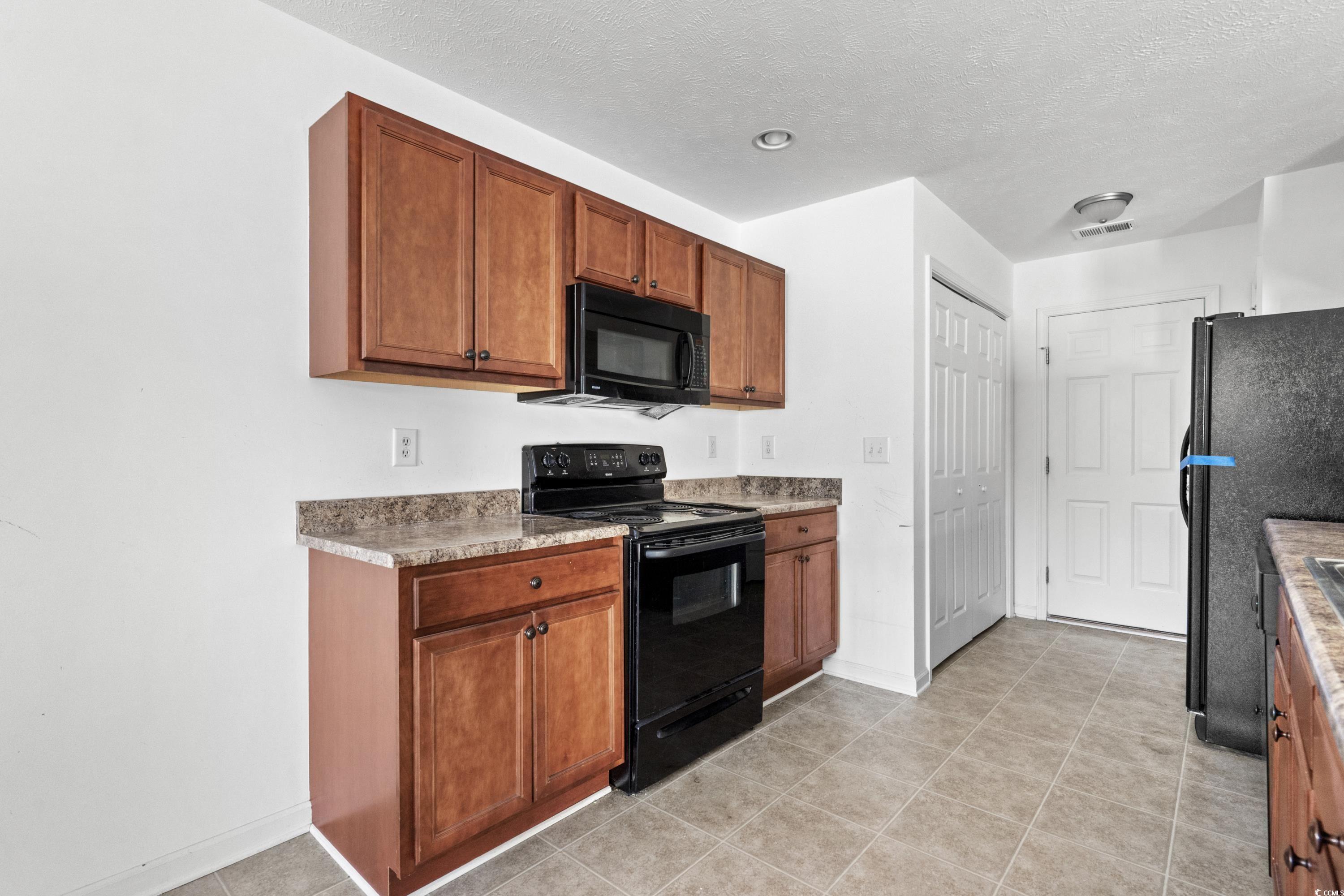 605 West Perry Road Myrtle Beach, SC 29579 - Photo 12 of 36 Kitchen with black appliances, light tile patterne