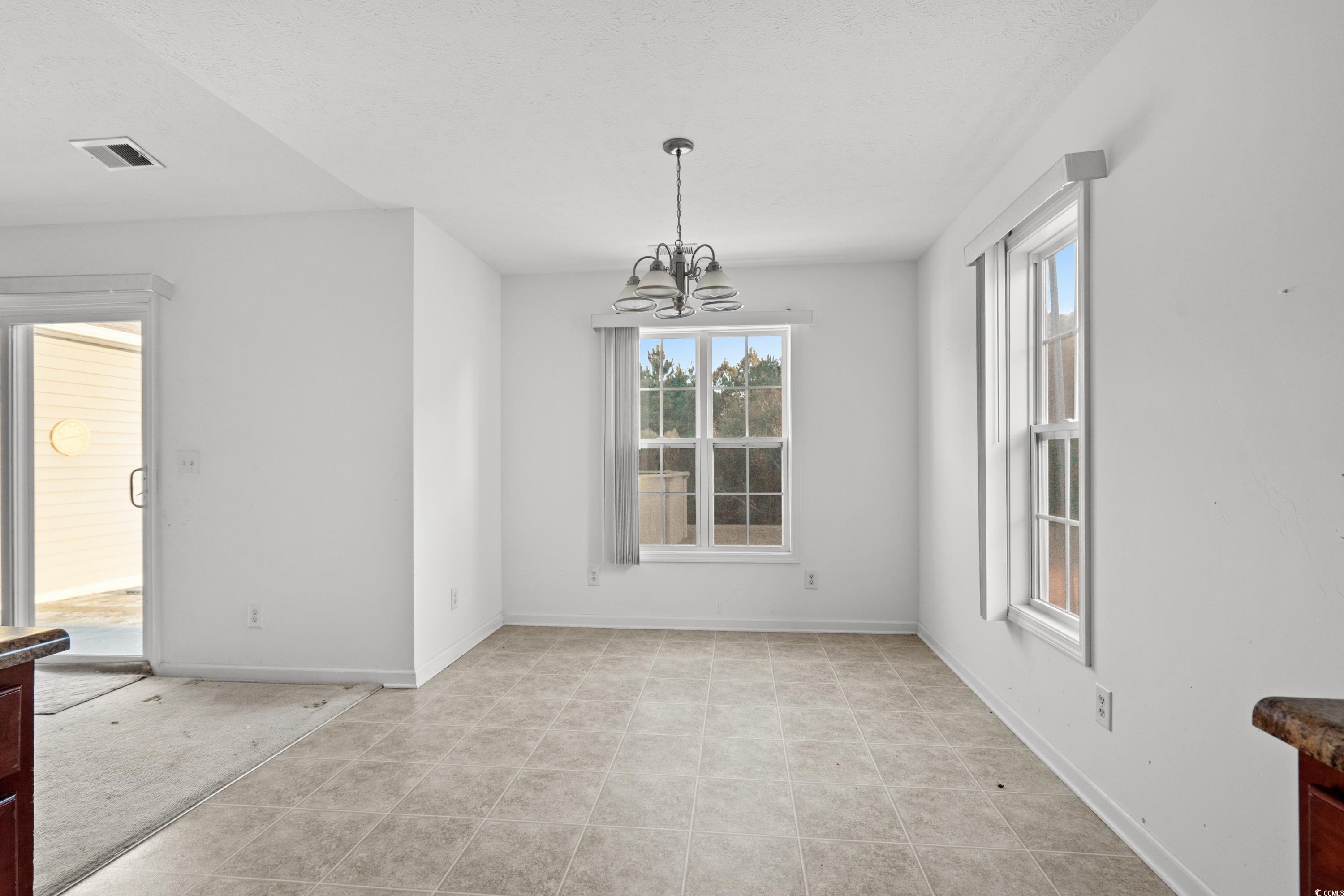 605 West Perry Road Myrtle Beach, SC 29579 - Photo 15 of 36 Unfurnished dining area with a notable chandelier