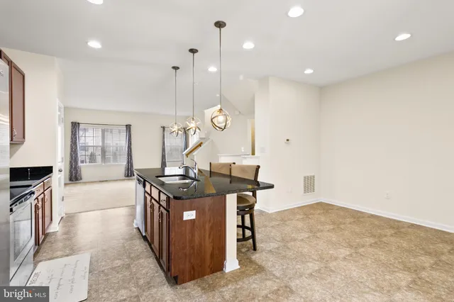 a living room with furniture a fireplace and a open kitchen view