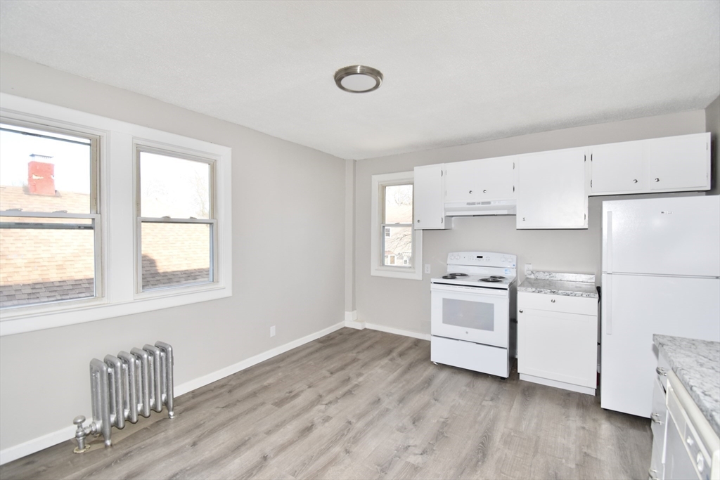 51-53 Eloise Street Springfield, MA 01118 - Photo 11 of 20 a kitchen with white cabinets and white appliances
