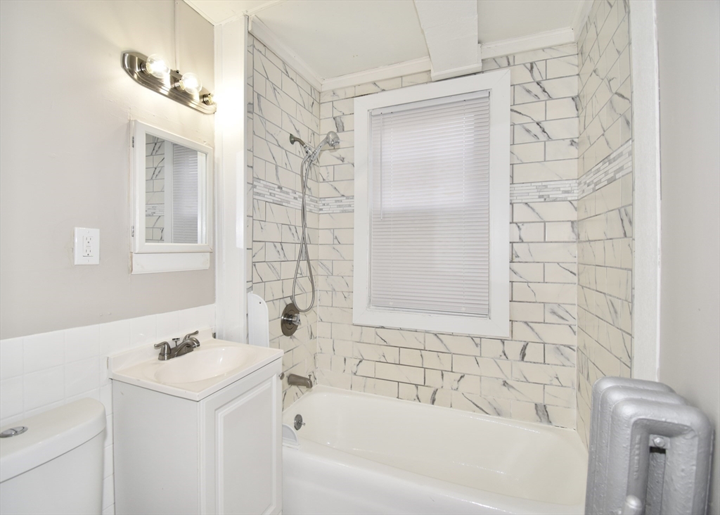 51-53 Eloise Street Springfield, MA 01118 - Photo 14 of 20 a bathroom with a sink a mirror and a bathtub