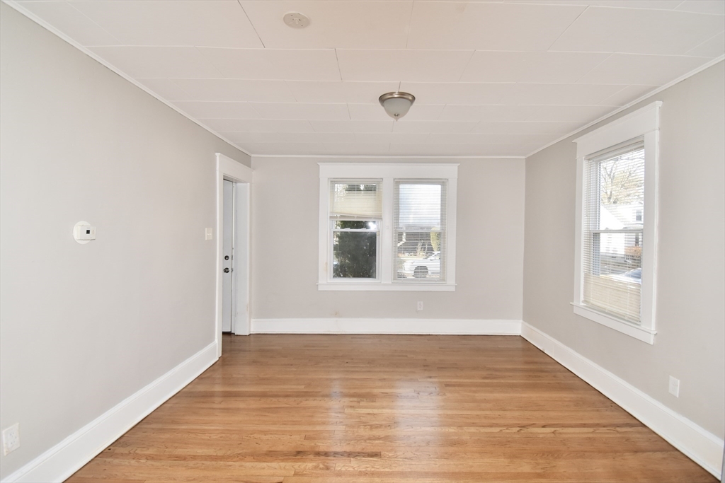 51-53 Eloise Street Springfield, MA 01118 - Photo 17 of 20 a view of an empty room with wooden floor and a window