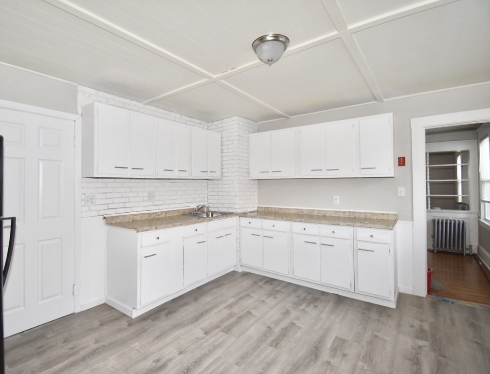 51-53 Eloise Street Springfield, MA 01118 - Photo 19 of 20 a kitchen with granite countertop white cabinets and white appliances