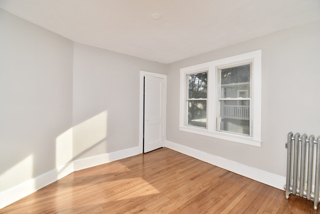 51-53 Eloise Street Springfield, MA 01118 - Photo 8 of 20 a view of an empty room with wooden floor and a window