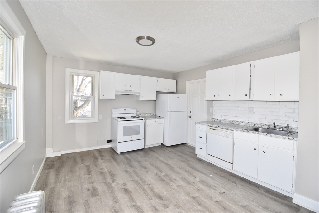 51-53 Eloise Street Springfield, MA 01118 - Photo 9 of 20 a kitchen with granite countertop white cabinets and white appliances