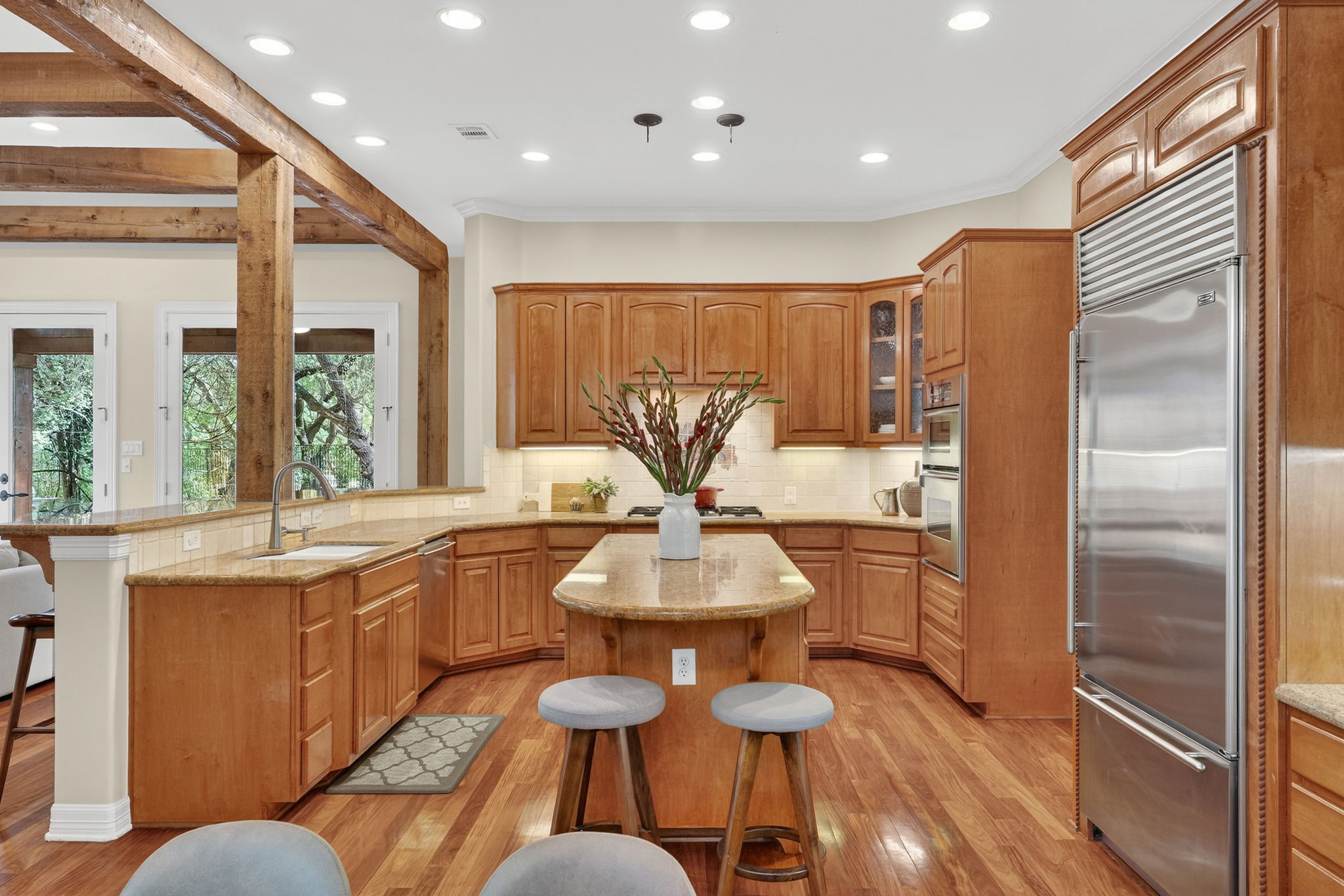 4110 Bunny Run, Unit 3 Austin, TX 78746 - Photo 11 of 35 This kitchen features rich wood cabinetry, granite countertops, and hardwood flooring
