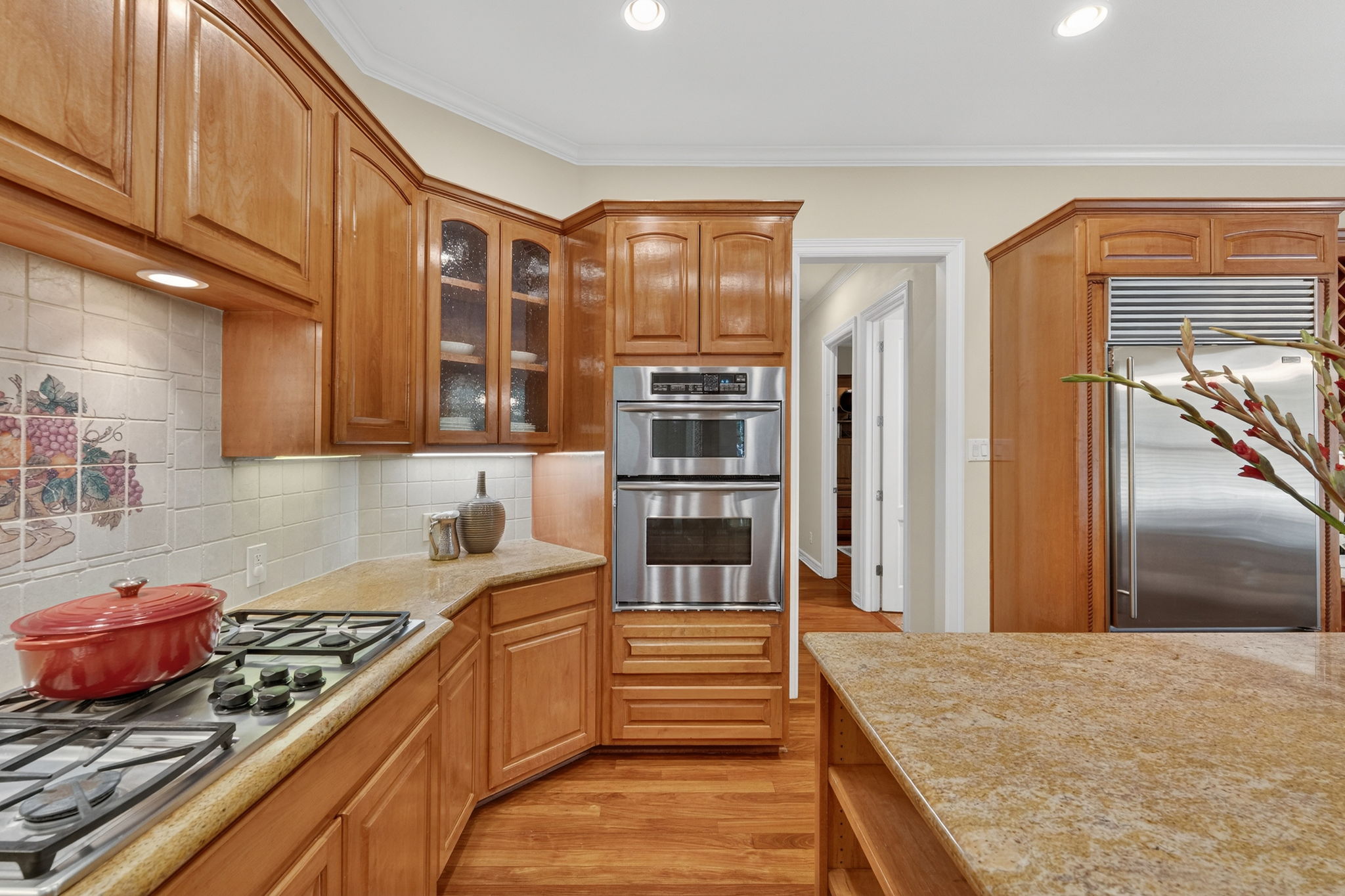 4110 Bunny Run, Unit 3 Austin, TX 78746 - Photo 12 of 35 The kitchen features wood cabinetry, light-colored countertops, and stainless steel appliances including double ovens and a built-in refrigerator
