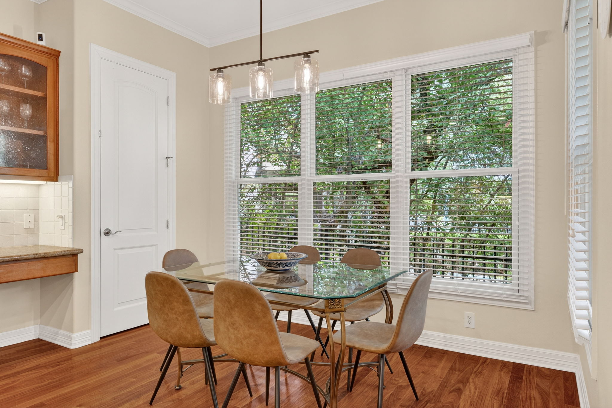 4110 Bunny Run, Unit 3 Austin, TX 78746 - Photo 13 of 35 This bright dining area features hardwood floors, a large window offering views of greenery, and a modern light fixture