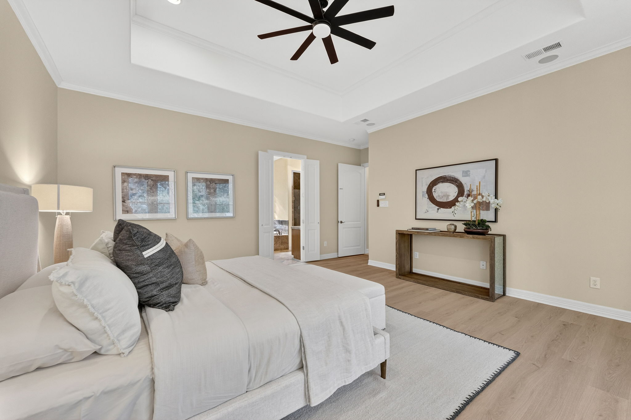 4110 Bunny Run, Unit 3 Austin, TX 78746 - Photo 15 of 35 Bedroom featuring light-toned walls, a tray ceiling with a ceiling fan, and light wood flooring