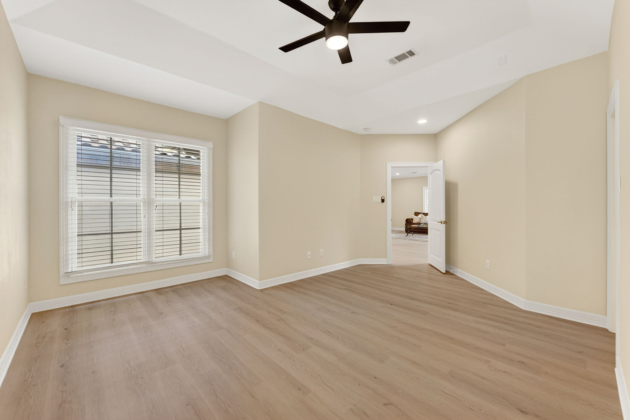 4110 Bunny Run, Unit 3 Austin, TX 78746 - Photo 23 of 35 This room features light-colored walls, light wood-style flooring, a tray ceiling, and a ceiling fan with integrated lighting