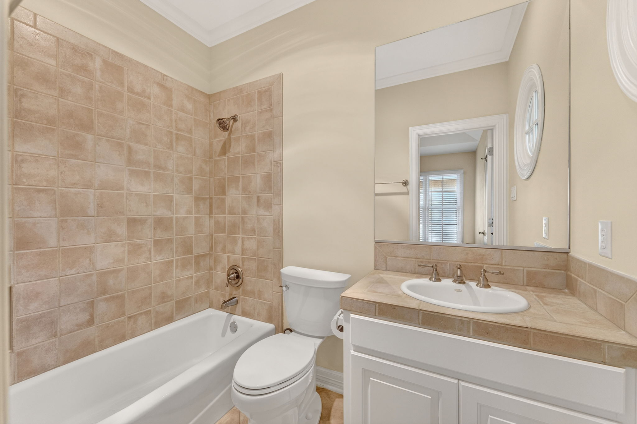 4110 Bunny Run, Unit 3 Austin, TX 78746 - Photo 24 of 35 Bathroom featuring a white bathtub, tiled shower walls, and a vanity with a drop-in sink and a large mirror