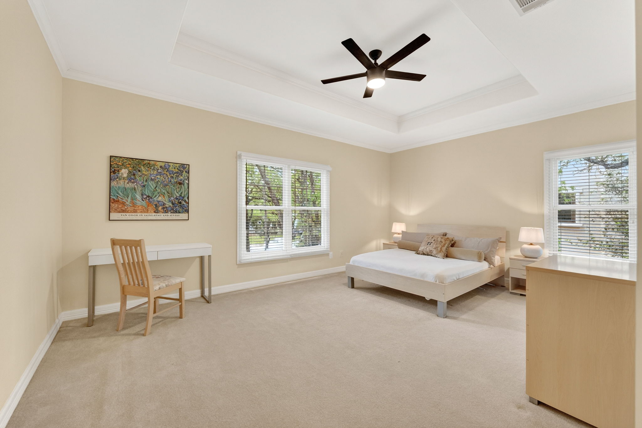 4110 Bunny Run, Unit 3 Austin, TX 78746 - Photo 25 of 35 This expansive room features light-colored carpet, a tray ceiling with a dark-toned ceiling fan, and crown molding