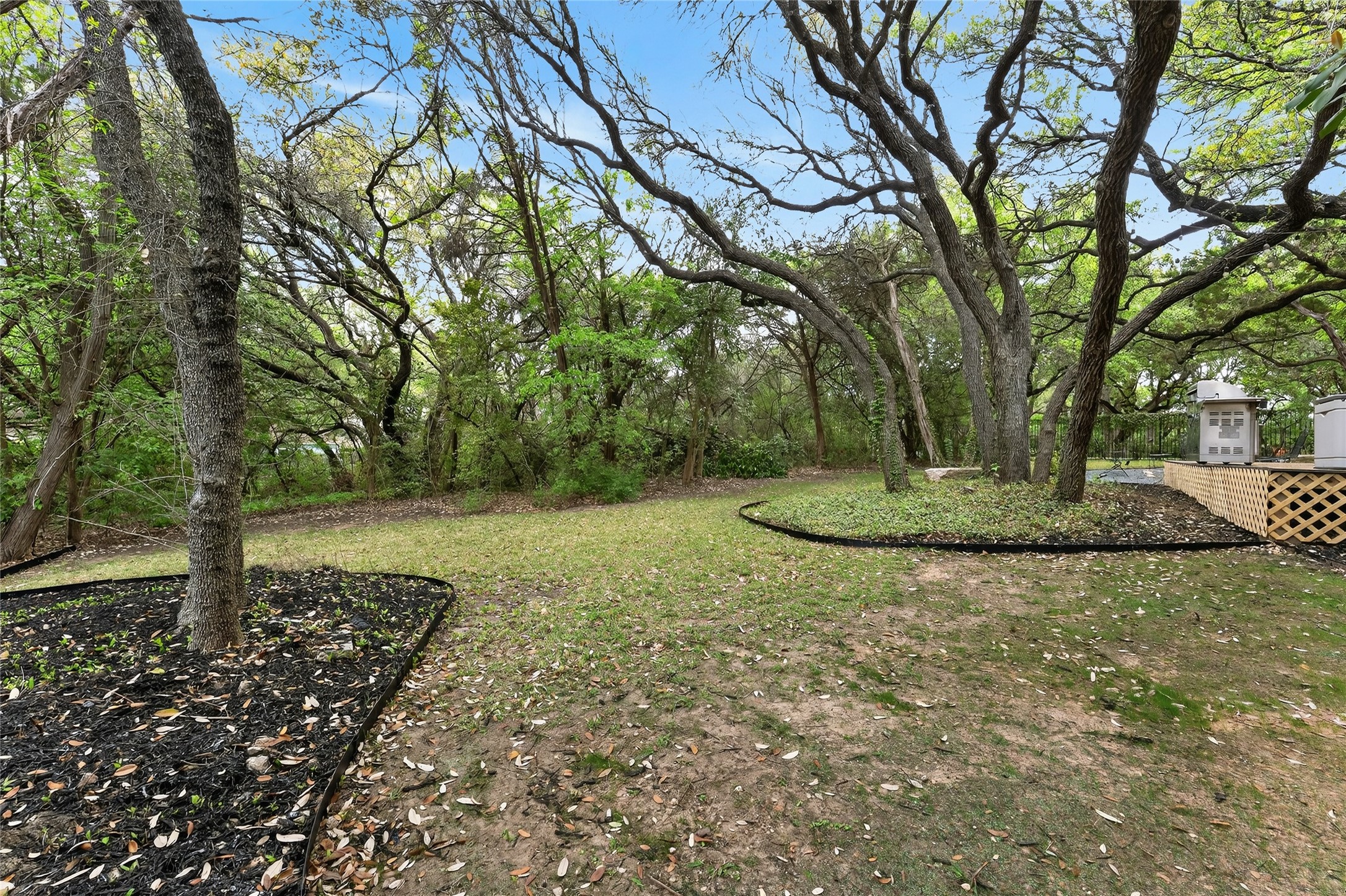 4110 Bunny Run, Unit 3 Austin, TX 78746 - Photo 33 of 35 The property features a spacious yard with mature trees and landscaping