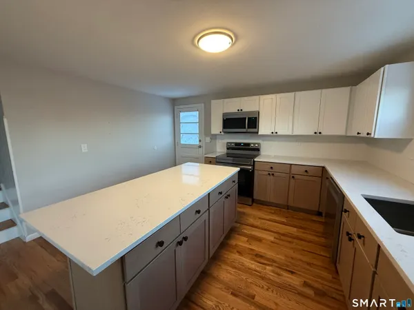 a kitchen with cabinets stainless steel appliances a sink and a stove