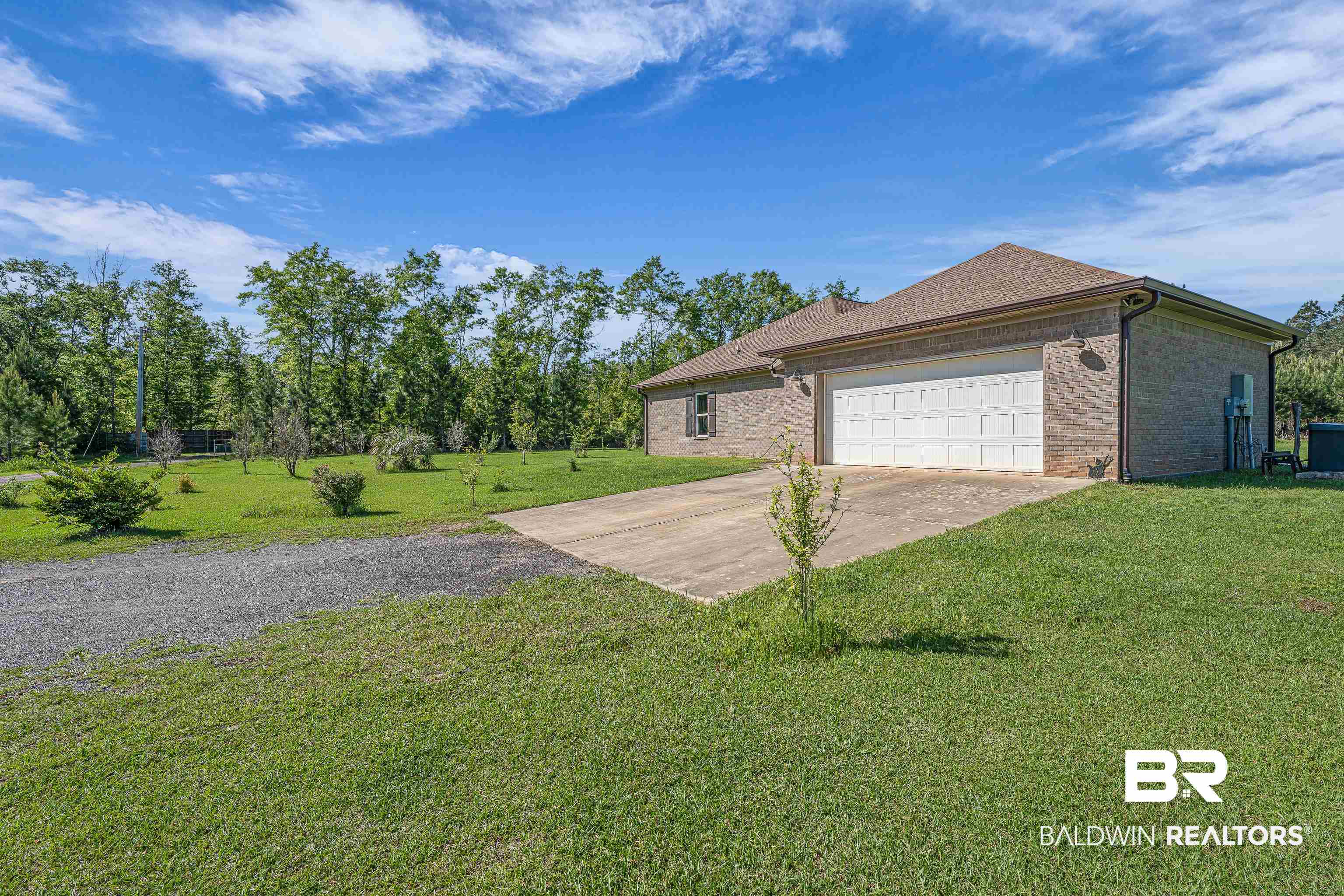18255 Cactus Court Elberta, AL 36530 - Photo 4 of 53 View of side of property featuring driveway, a lawn, brick siding, a garage, and a shingled roof