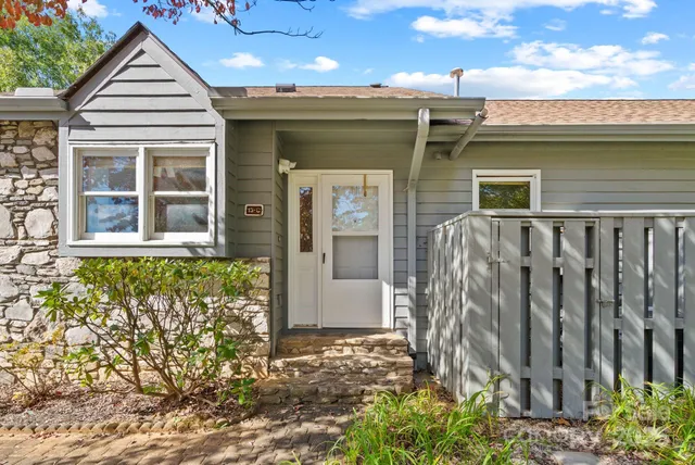 a view of a house with a door and a bench
