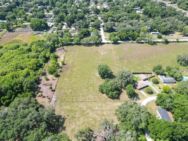 an aerial view of a house with a yard and lake view