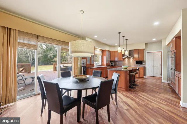 a kitchen with stainless steel appliances granite countertop a stove a refrigerator a oven a sink with island and chairs